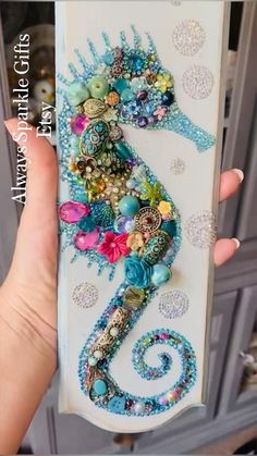 a hand holding up a phone case with a sea horse on it's side