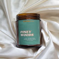 a jar of piney woods sits on a white fabric