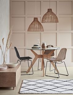 a dining room with pink walls and chairs