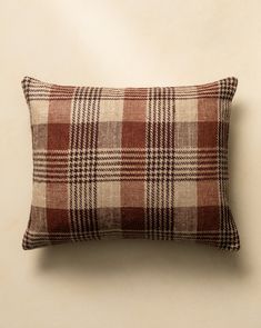 a brown and white plaid pillow sitting on top of a wall