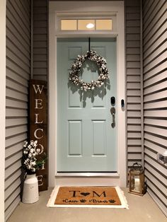 a front door with a welcome mat and wreath