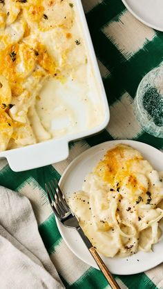 a white plate topped with mashed potatoes next to a casserole dish on a green and white checkered table cloth