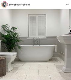 a white bath tub sitting next to a toilet in a bathroom