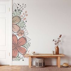 a room with flowers painted on the wall and a wooden bench in front of it