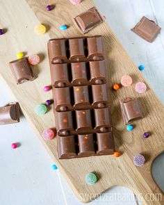 there is a chocolate bar on the cutting board with sprinkles around it