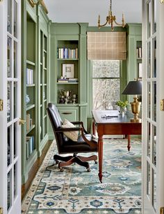 an office with green walls and carpeted flooring is seen through the doorway to another room