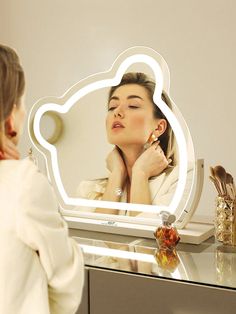 a woman is looking at her reflection in the mirror while she brushes her teeth with an electric toothbrush