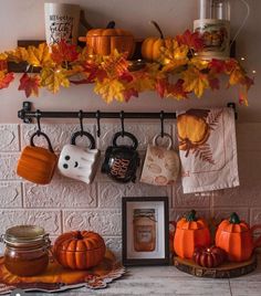 the kitchen counter is decorated with pumpkins and other autumn decorations, including mugs