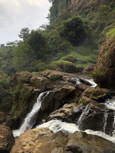 there is a small waterfall in the middle of some rocks