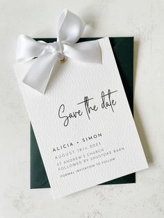 a wedding save the date card with a white bow