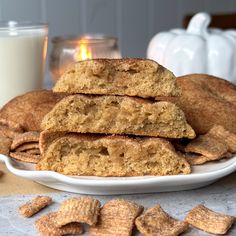 a white plate topped with cookies next to a glass of milk and some crackers