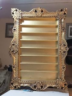 a mirror that is sitting on top of a table in front of a wall mounted shelf