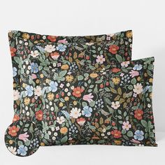 two black floral pillows on a white surface