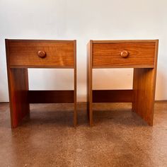 two wooden nightstands sitting next to each other