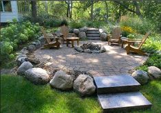 an outdoor fire pit surrounded by rocks and chairs