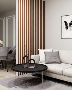 a living room filled with furniture next to a dining room table and wall mounted pictures