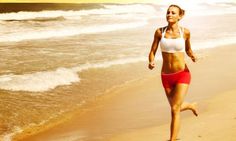 a woman is running on the beach near the water