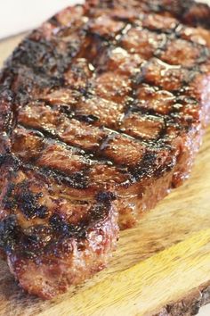 a piece of steak sitting on top of a wooden cutting board