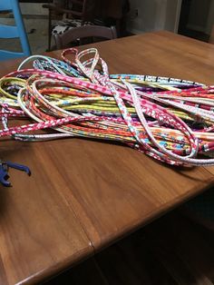 a pile of colorful cords sitting on top of a wooden table