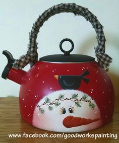 a red tea kettle with a bird painted on it