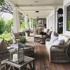 a porch with wicker furniture and flowers on it