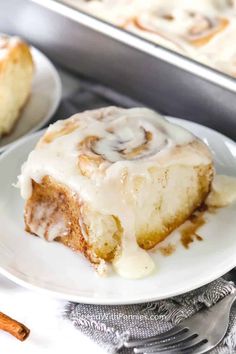 cinnamon roll on a plate with icing drizzled over it