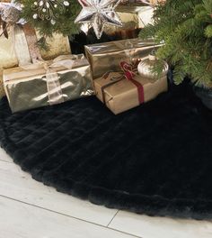 presents under the christmas tree on a black rug