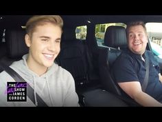 two men sitting in the back seat of a car, one smiling at the camera