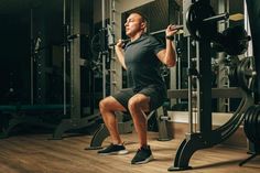 a man doing squats in the gym