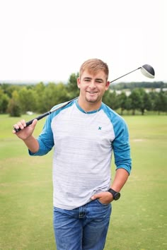 a man holding a golf club in his right hand