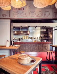 the inside of a restaurant with wooden tables and stools