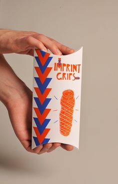 a hand holding an orange and blue book with the title imprint crafts written on it