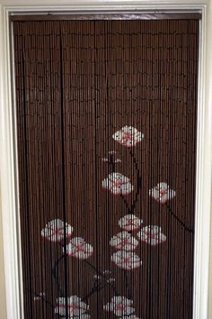 a bicycle is painted on the side of a bamboo screen door in front of a window