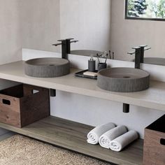 a bathroom with two sinks and towels on the counter