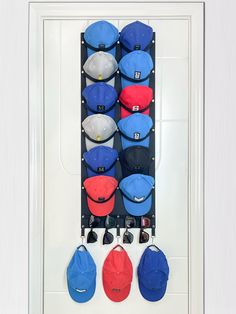 several hats are hanging on the wall with sunglasses and baseball caps attached to it's hooks