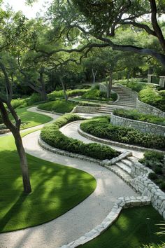 an outdoor garden with green grass and stone steps leading up to the top of it