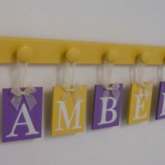 the name amber hanging on a wall in purple and yellow