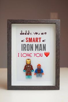 two legos are sitting in front of a framed sign that says, smart iron man i love you