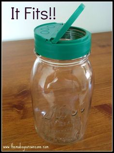 a glass jar with a green lid and a plastic spoon in it on a wooden table