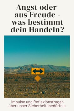 a yellow sign sitting on the side of a road next to a desert area with mountains in the background