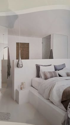 a white bed sitting in a bedroom next to a mirror on the side of a wall