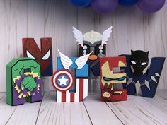 the letters are made out of paper and have superheros on them, including captain america