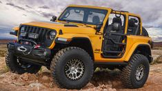 a yellow jeep parked on top of a rocky hill