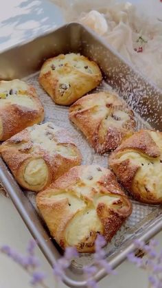 several pastries are sitting in a pan on a table next to lavenders and flowers