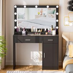 a bedroom with a vanity, mirror and bed in the background is lit up by lights