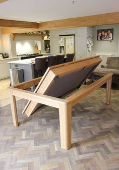 a wooden bench sitting in the middle of a living room next to a dining room table