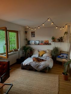 a bed sitting on top of a wooden floor in a bedroom next to a window