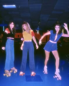 three young women standing on skateboards in a room