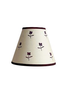 a white lamp shade with purple flowers on the bottom and red trimmings around it