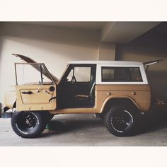 an old jeep is parked in a garage